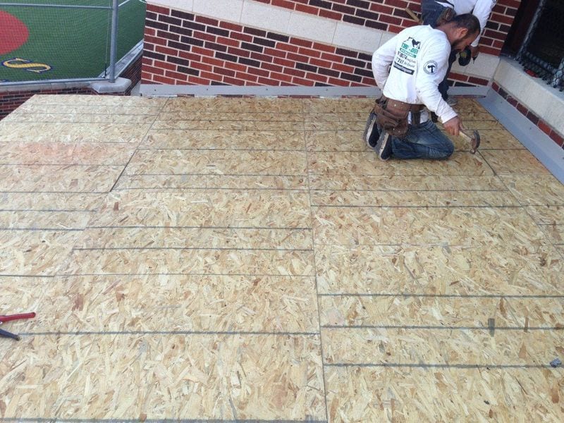 a man wearing a shirt that says ' roofing ' on it
